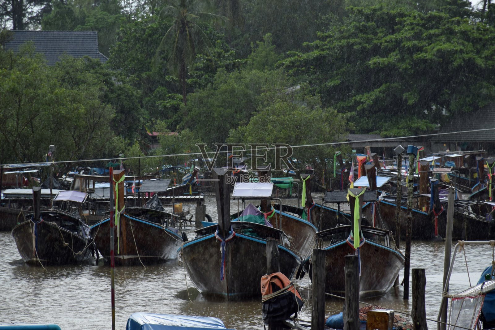 长尾船和渔村在雨天在甲米，泰国照片摄影图片
