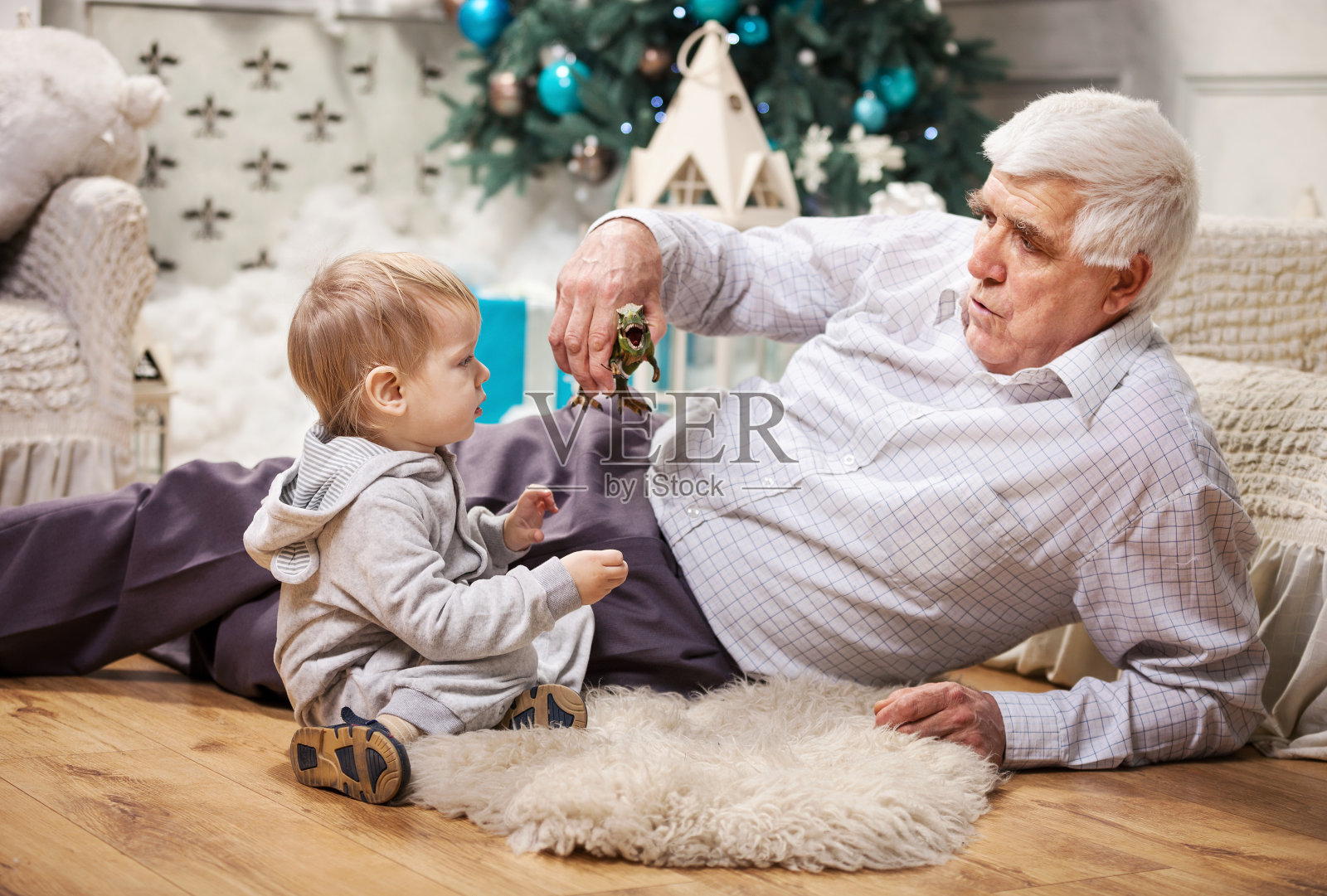 蹒跚学步的男孩和他的爷爷在玩玩具照片摄影图片