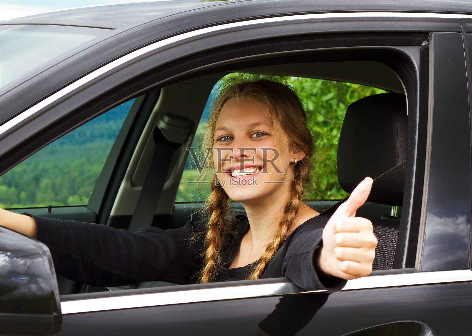 年轻女子在车里竖起大拇指照片摄影图片