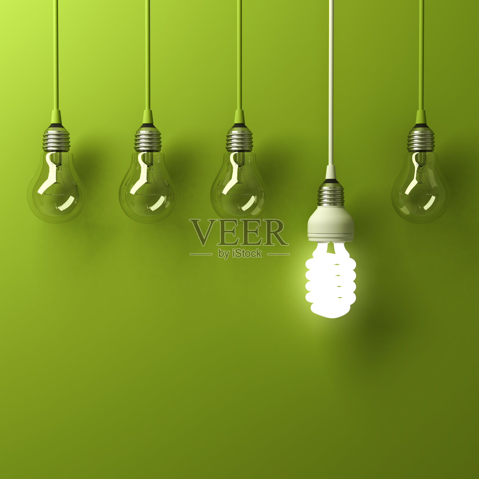 一个悬挂的节能灯泡在绿色的背景上反射不同的白炽灯泡，领导和不同的创意概念照片摄影图片