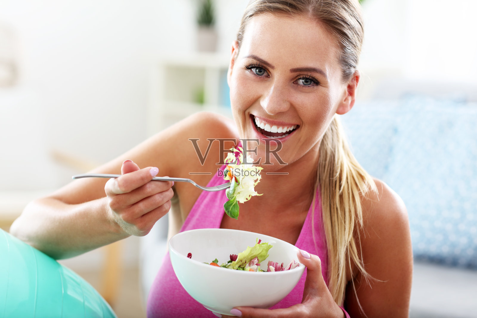 年轻女子在锻炼后吃健康的沙拉照片摄影图片