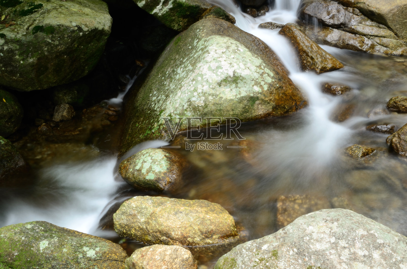 水流过岩石。照片摄影图片