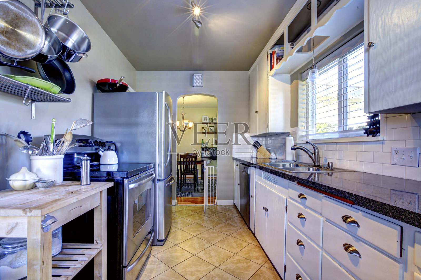 蓝色的厨房内部，棕色的瓷砖和不锈钢冰箱照片摄影图片