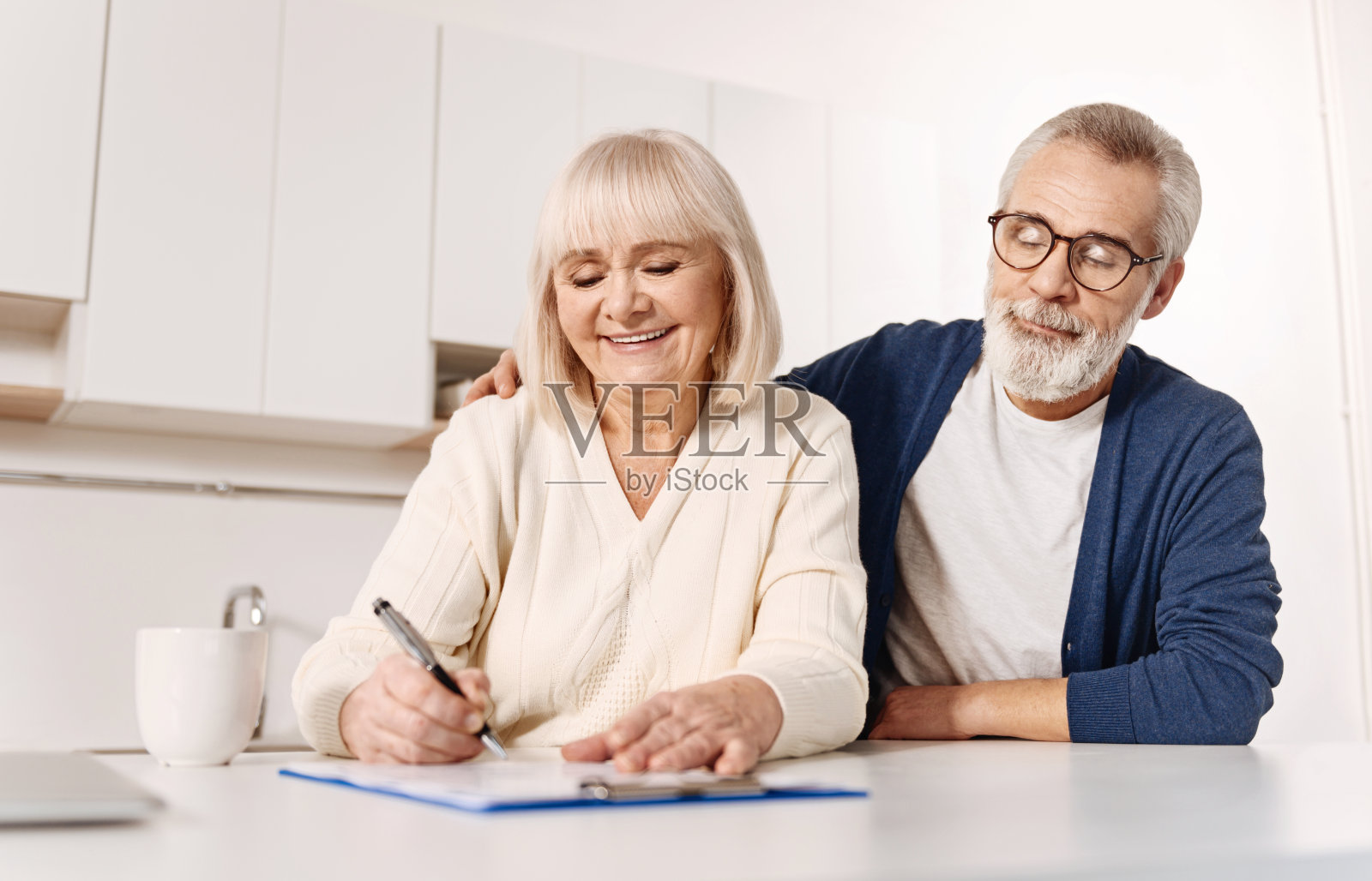一对和谐的老夫妇在家里签署文件照片摄影图片