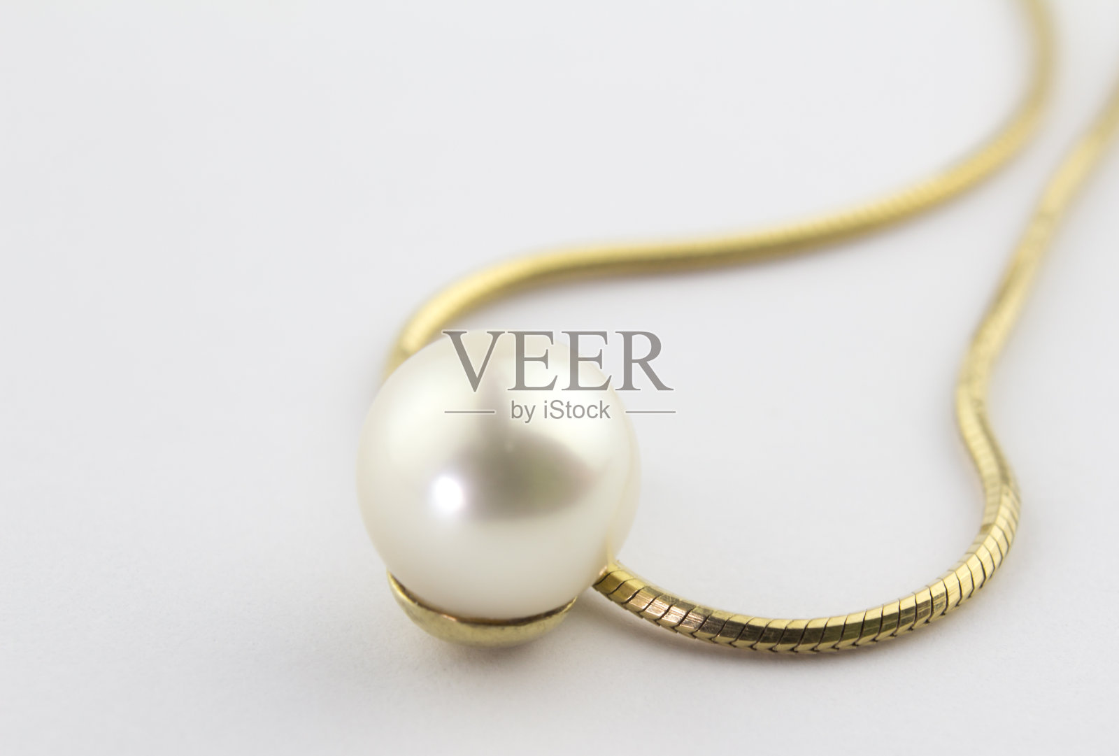 单珍珠坠子上的金链孤立在白色的背景照片摄影图片