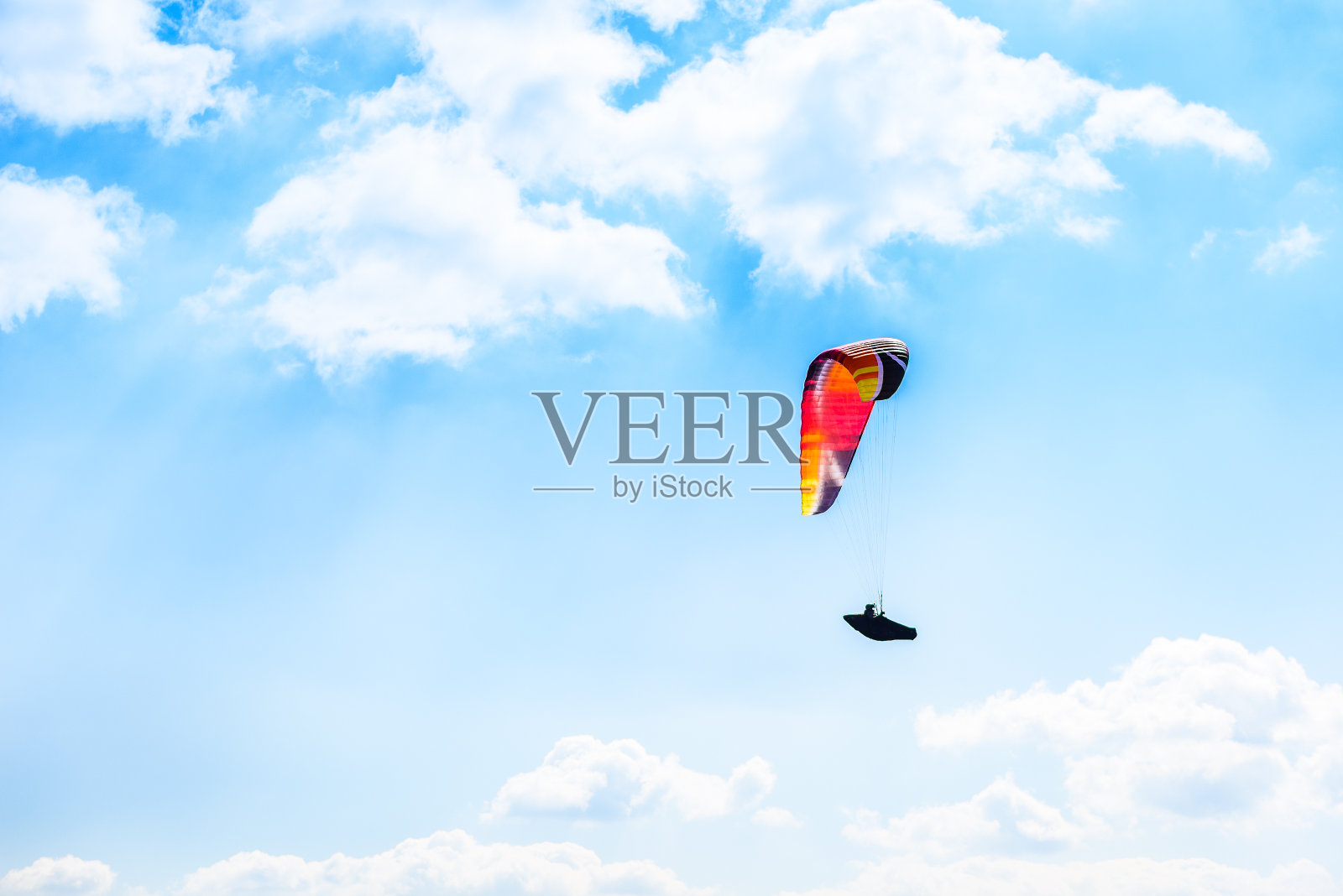 滑翔伞在蓝天白云中飞行。照片摄影图片