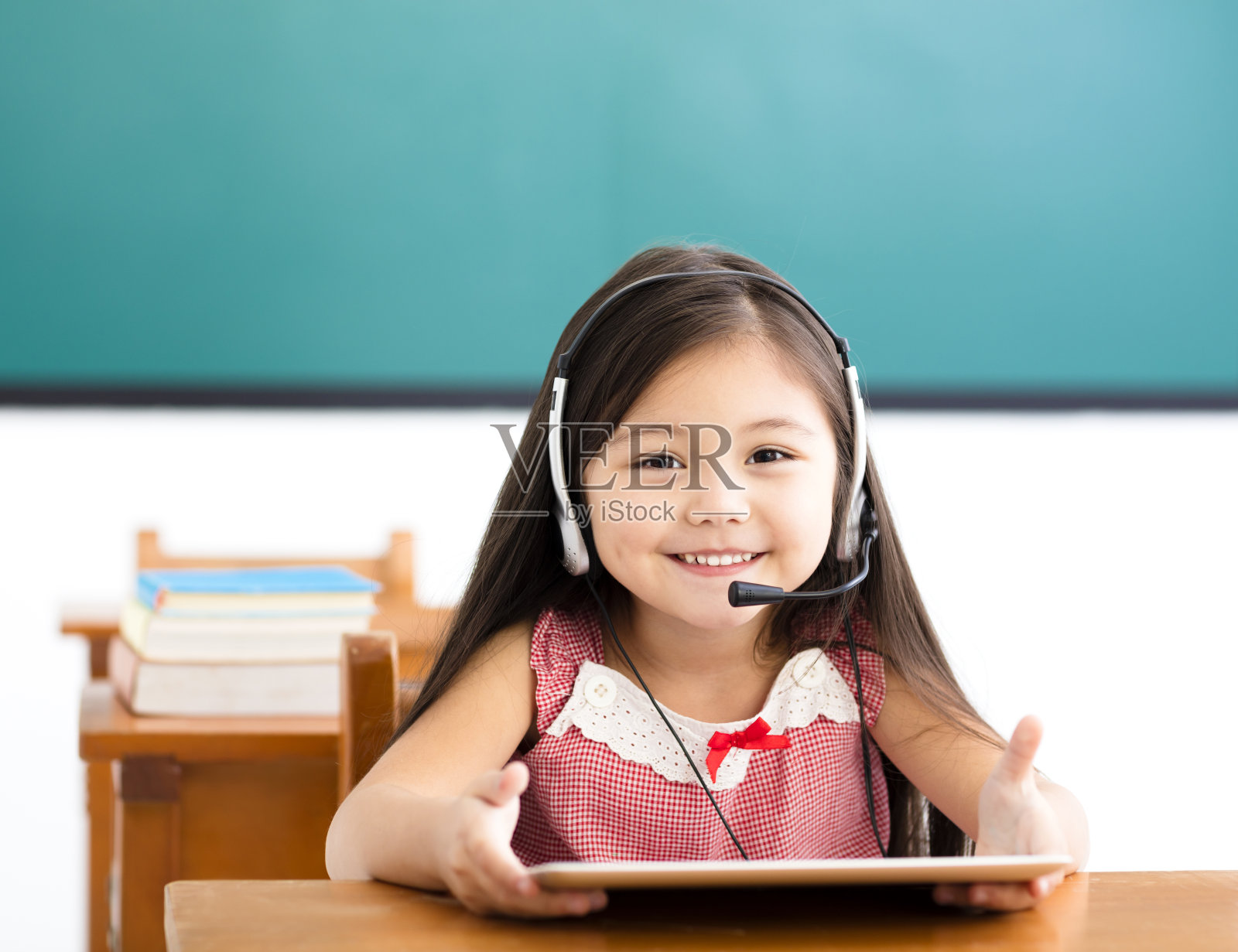 快乐的小女孩在课堂上使用数码平板电脑照片摄影图片