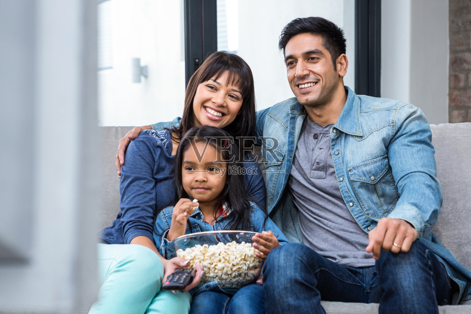 一家人边看电视边吃爆米花照片摄影图片