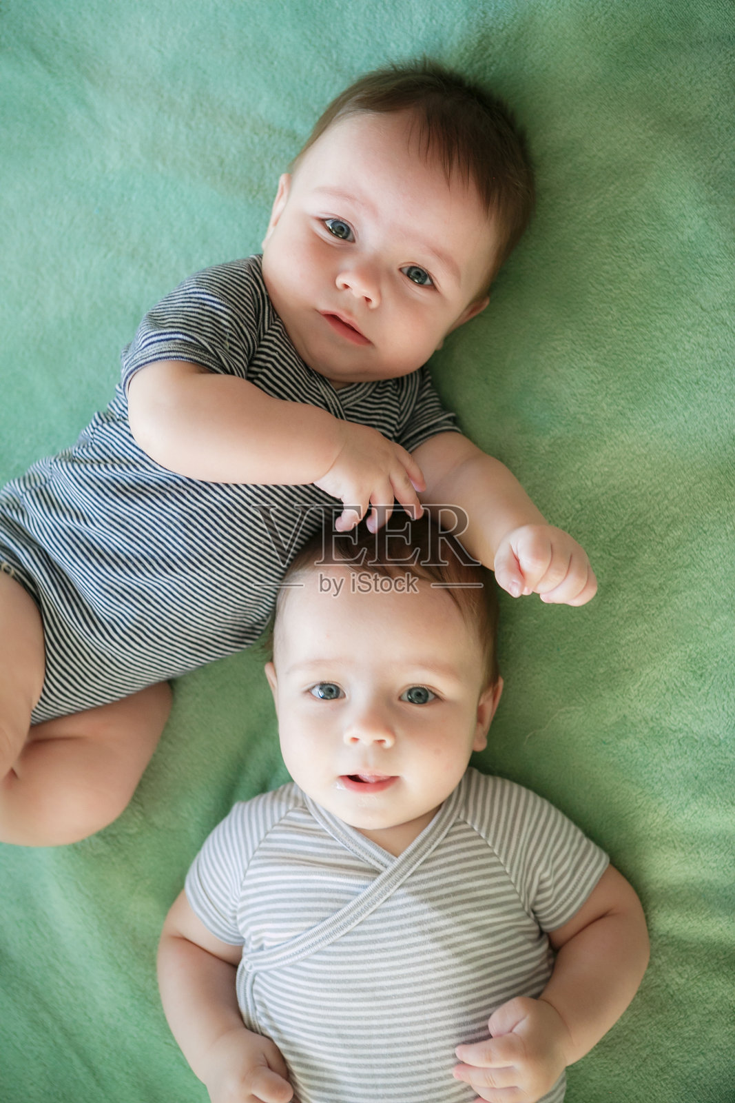 刚出生的双胞胎男孩躺在床上照片摄影图片