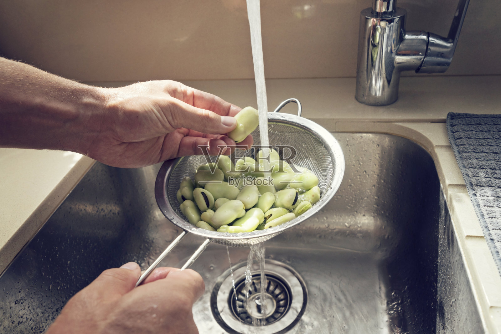 男人的手在筛子里洗新鲜的绿豆照片摄影图片