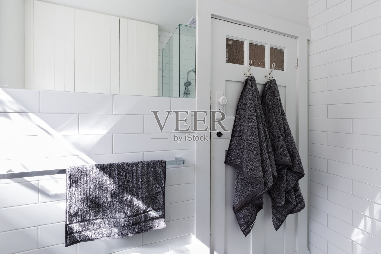 豪华毛巾挂在现代白色浴室的门钩上照片摄影图片