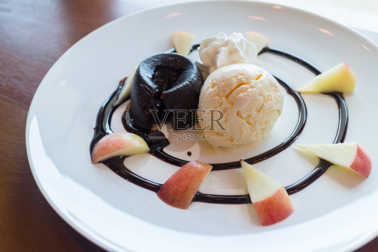 热巧克力熔岩蛋糕，香草冰淇淋球，苹果照片摄影图片
