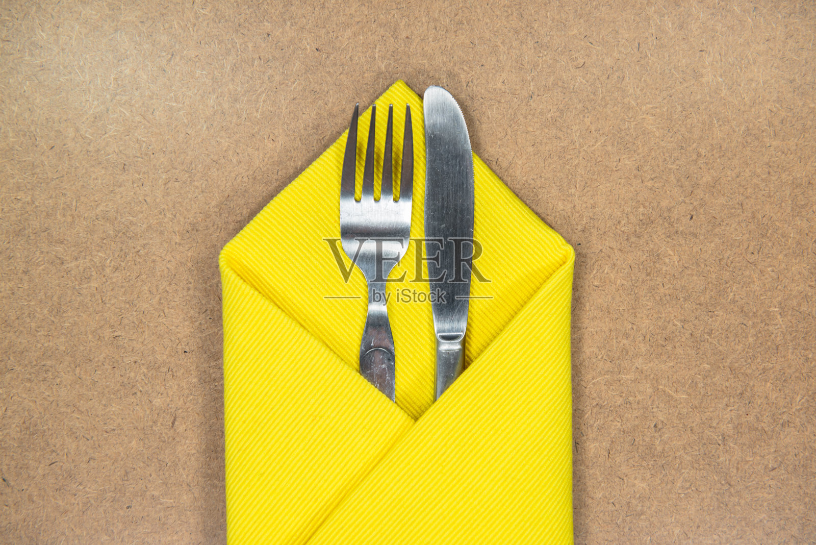 用黄色餐巾包着的刀叉照片摄影图片