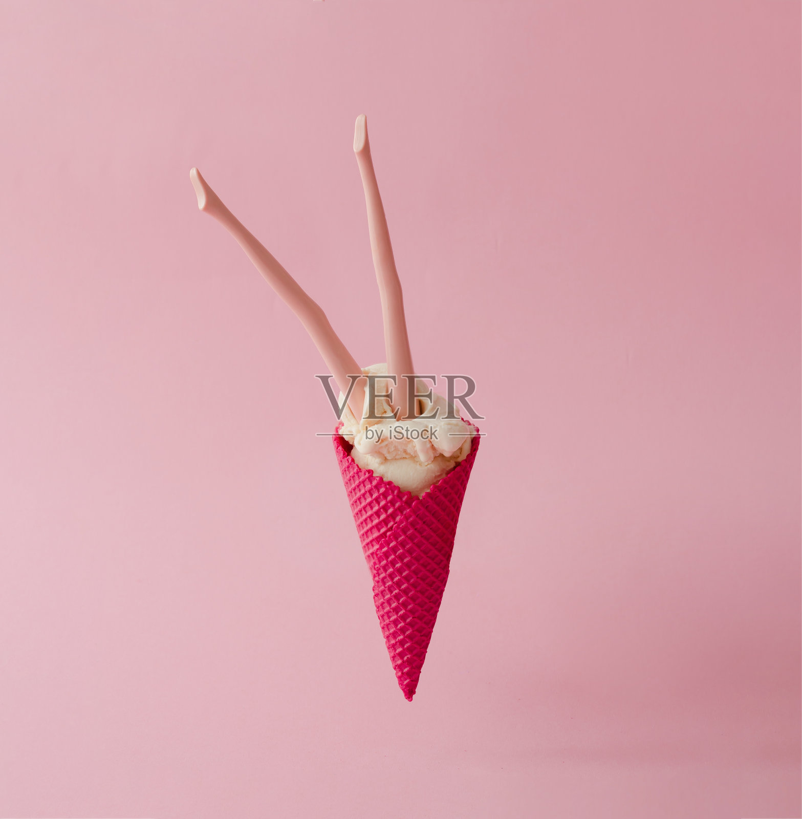 娃娃腿在香草冰淇淋与红色蛋筒在粉红色的背景。创造性的夏天的概念。照片摄影图片