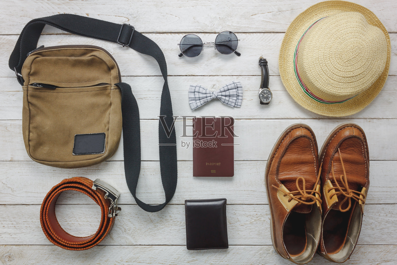 俯视图配件旅行与男装概念上的木材背景。男士物品领结、钱包、皮鞋、手表、太阳镜、手袋、帽子、腰带、护照等木质背景。白色的空白。照片摄影图片