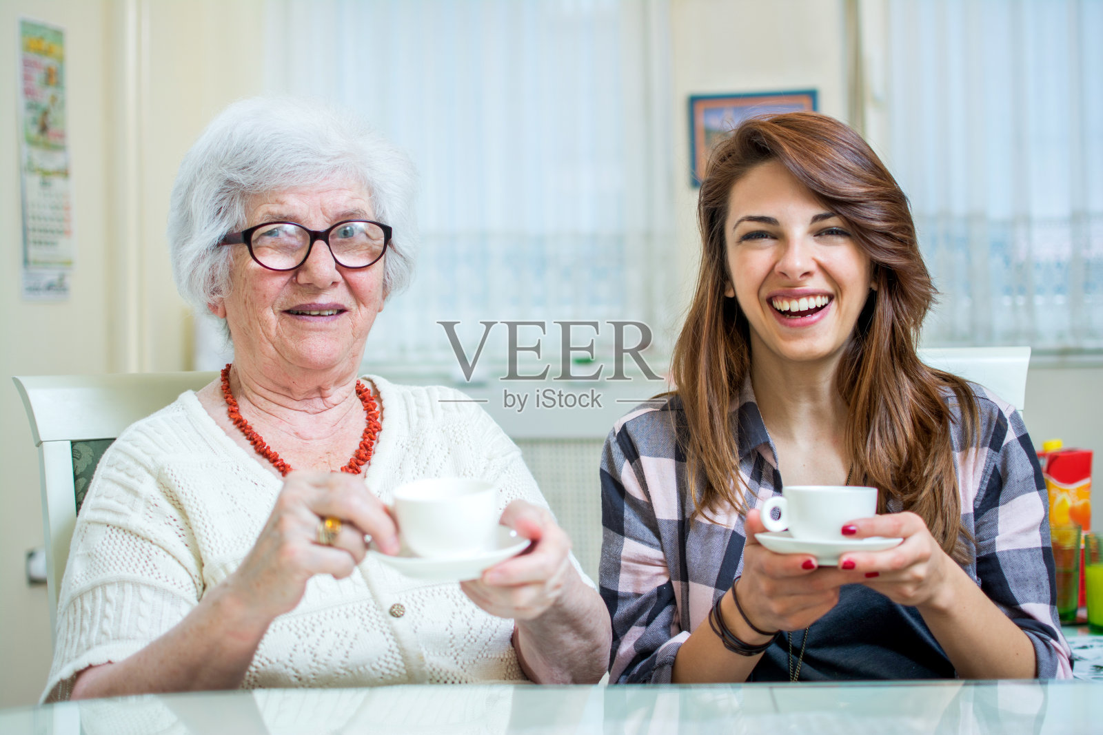 一个奶奶和她的孙女在家里喝咖啡聊天的肖像。照片摄影图片
