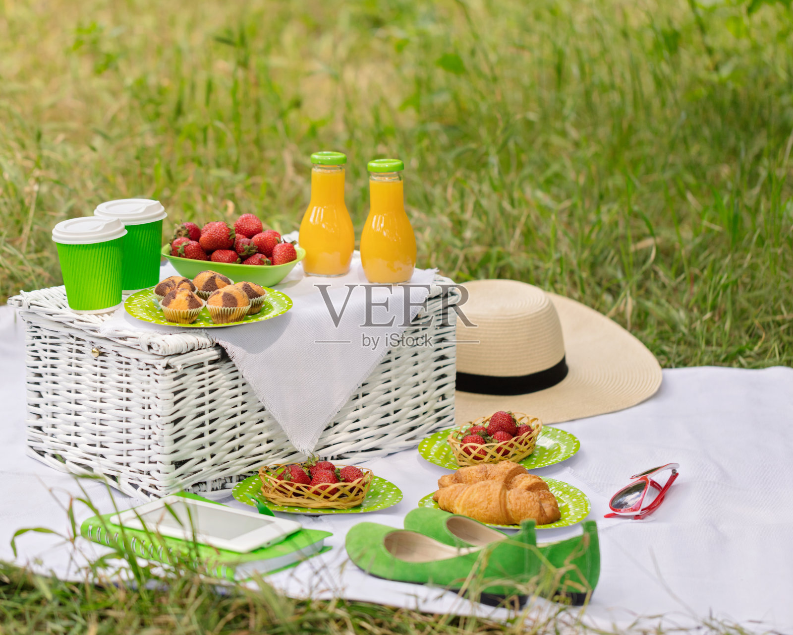 夏天:在草地上野餐——咖啡和牛角面包，果汁和浆果。照片摄影图片