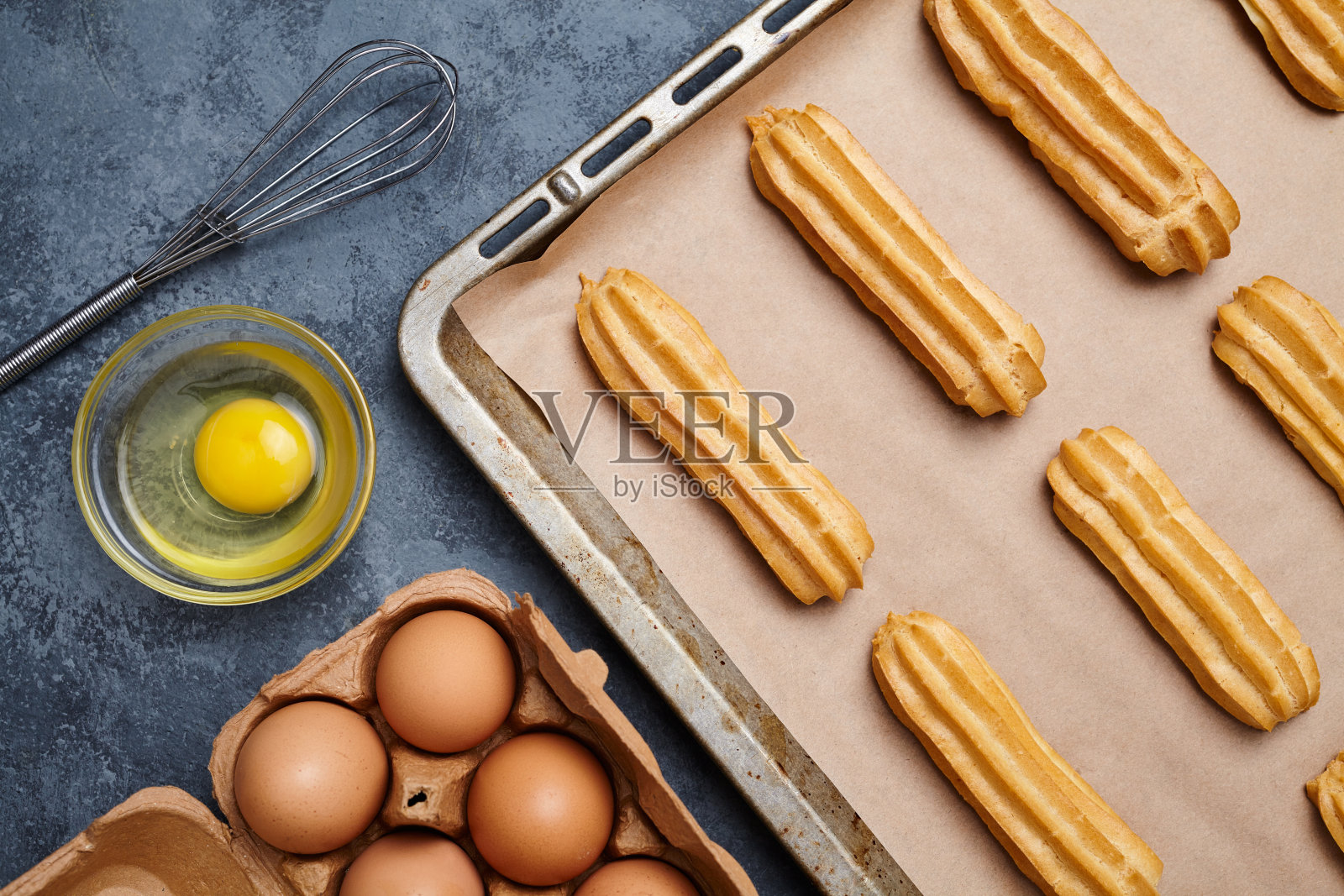 在烤盘上加入鸡蛋的泡芙或泡芙照片摄影图片