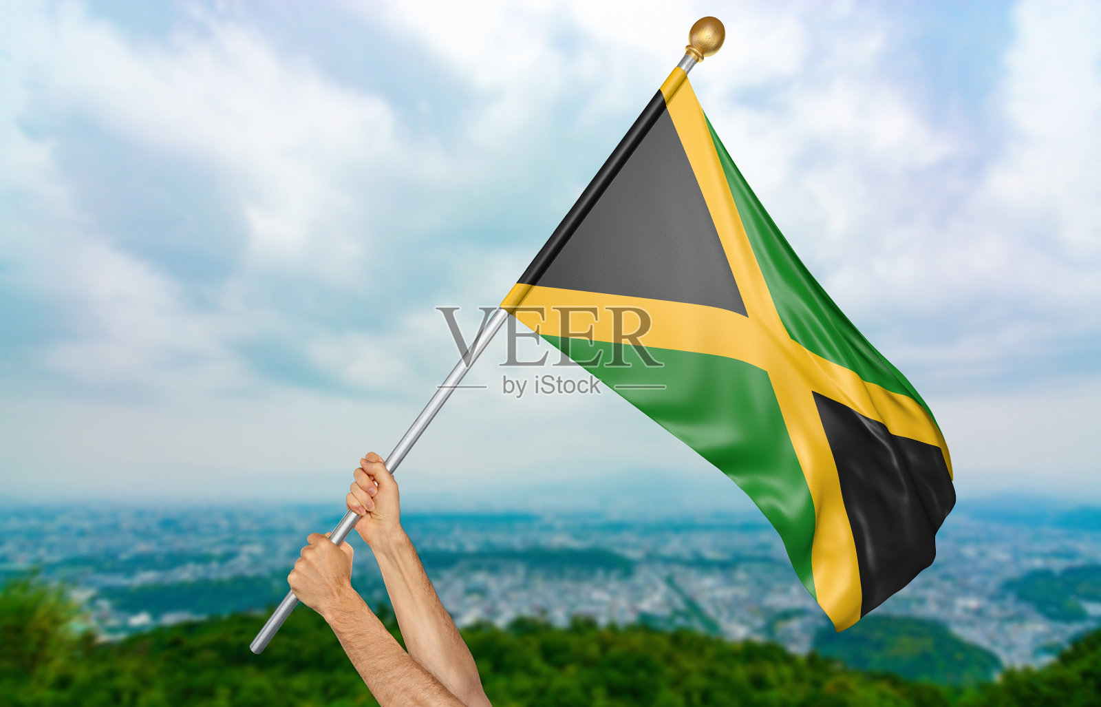 年轻人的手在天空中自豪地挥舞着牙买加国旗照片摄影图片