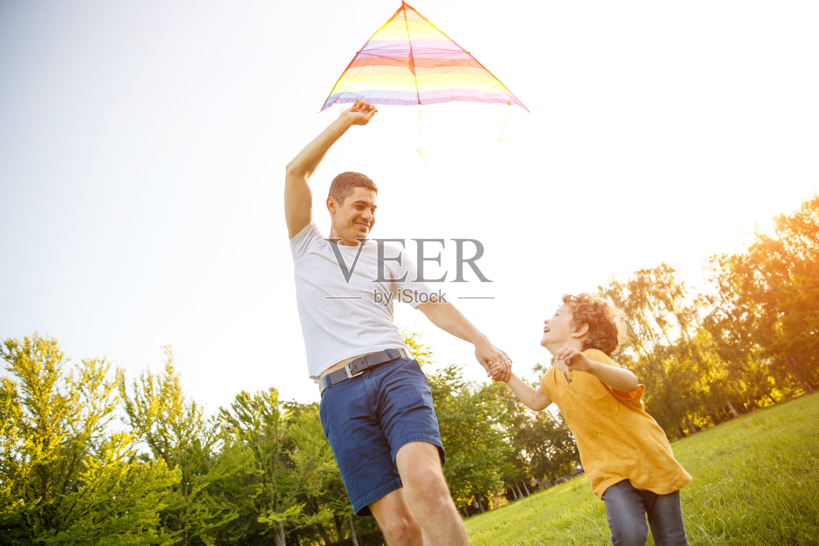 兴奋的男孩和父亲放风筝照片摄影图片