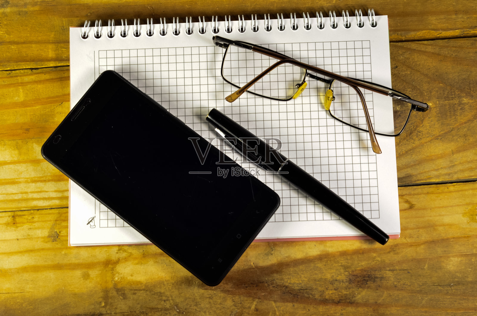 钢笔、智能手机和笔记本上的眼镜照片摄影图片
