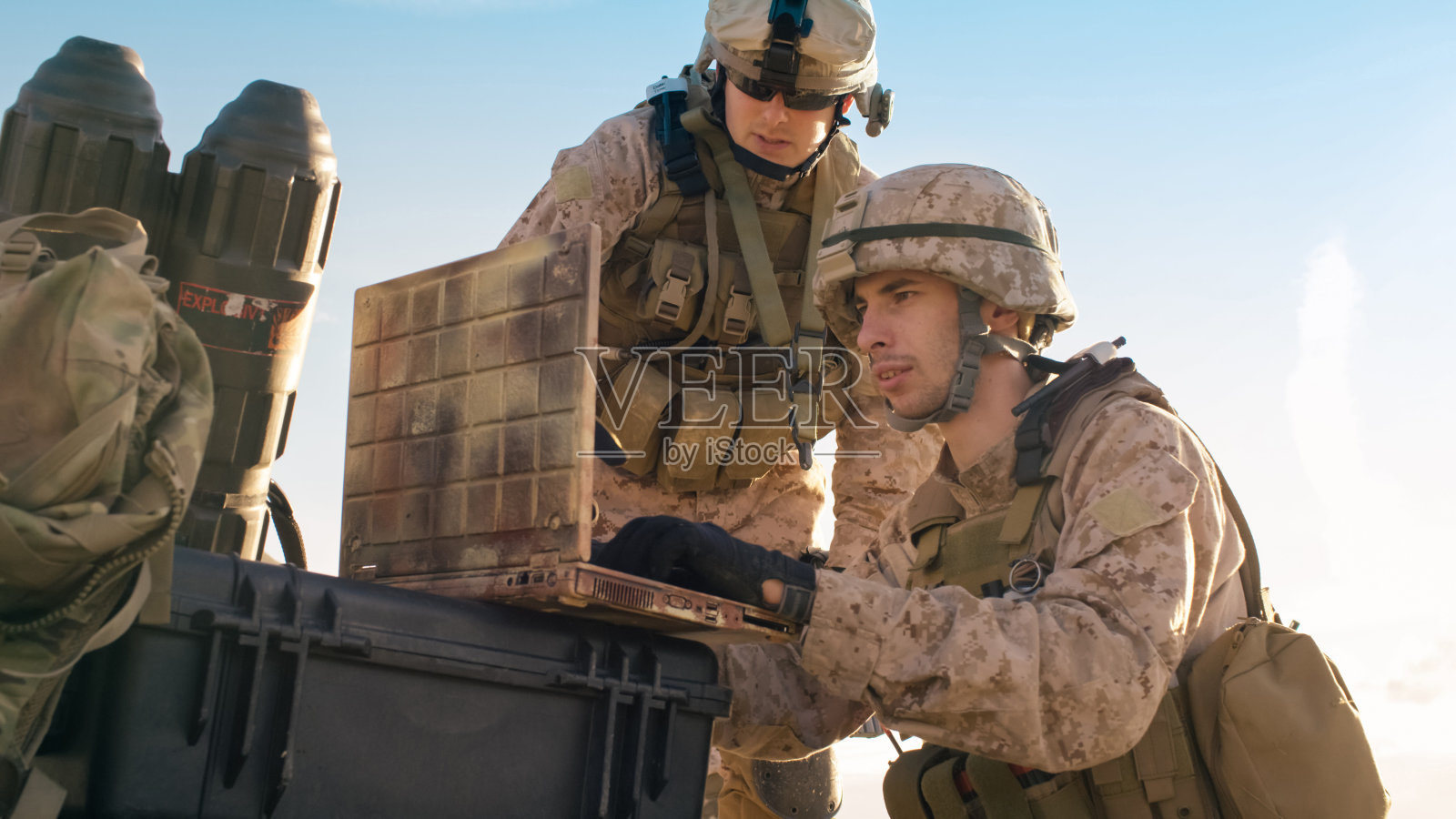 在沙漠军事行动中，士兵们正在使用笔记本电脑进行监视。照片摄影图片