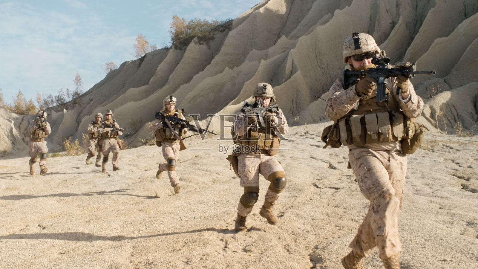全副武装的士兵在沙漠中奔跑。显示运动。照片摄影图片