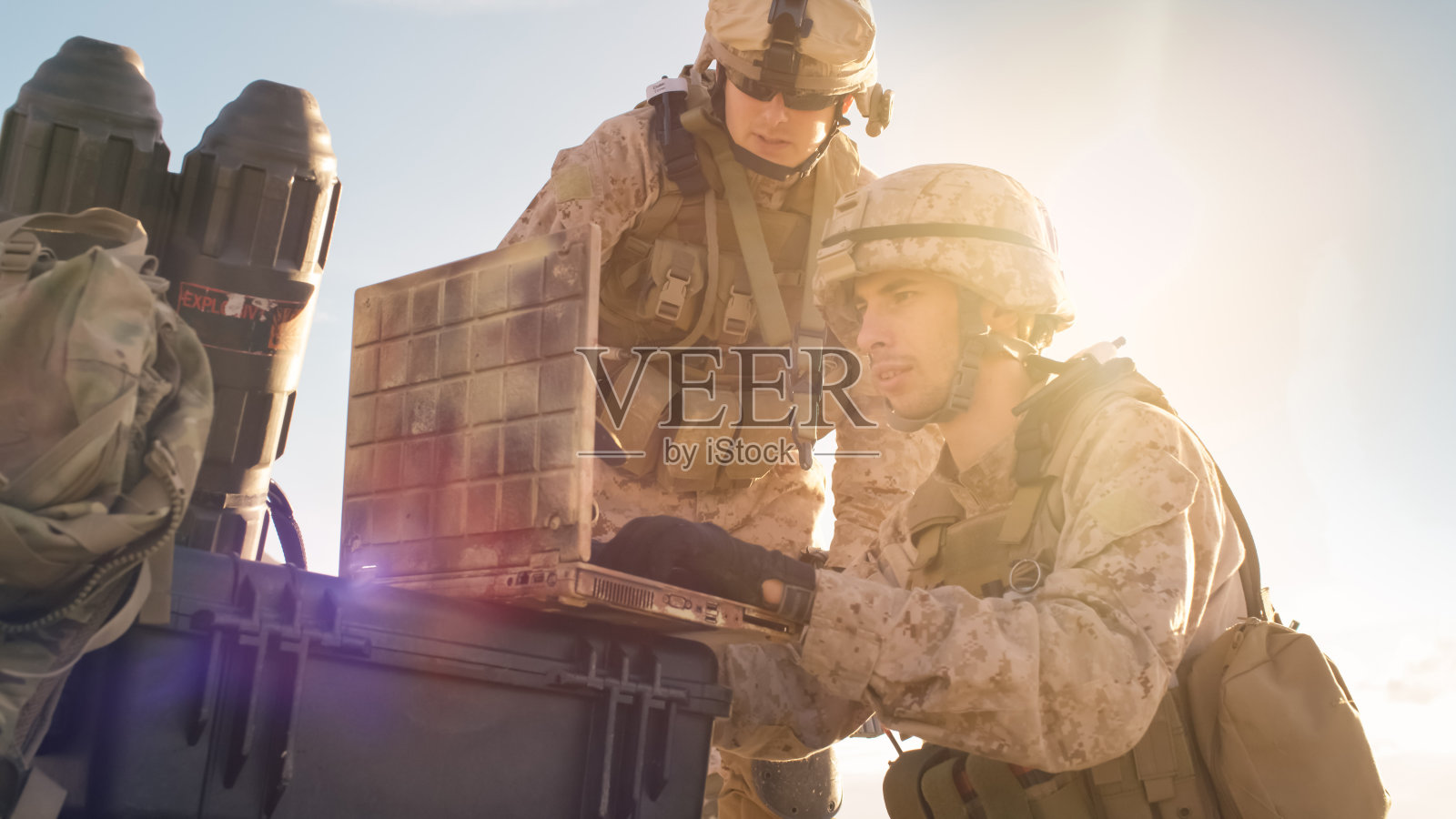 士兵在沙漠军事行动中使用笔记本电脑进行监视的特写镜头。照片摄影图片