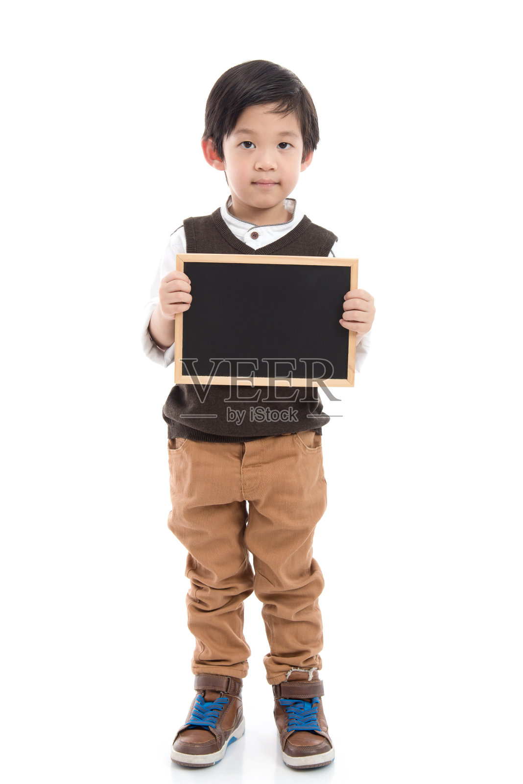 可爱的亚洲男孩拿着黑板在白色的背景照片摄影图片