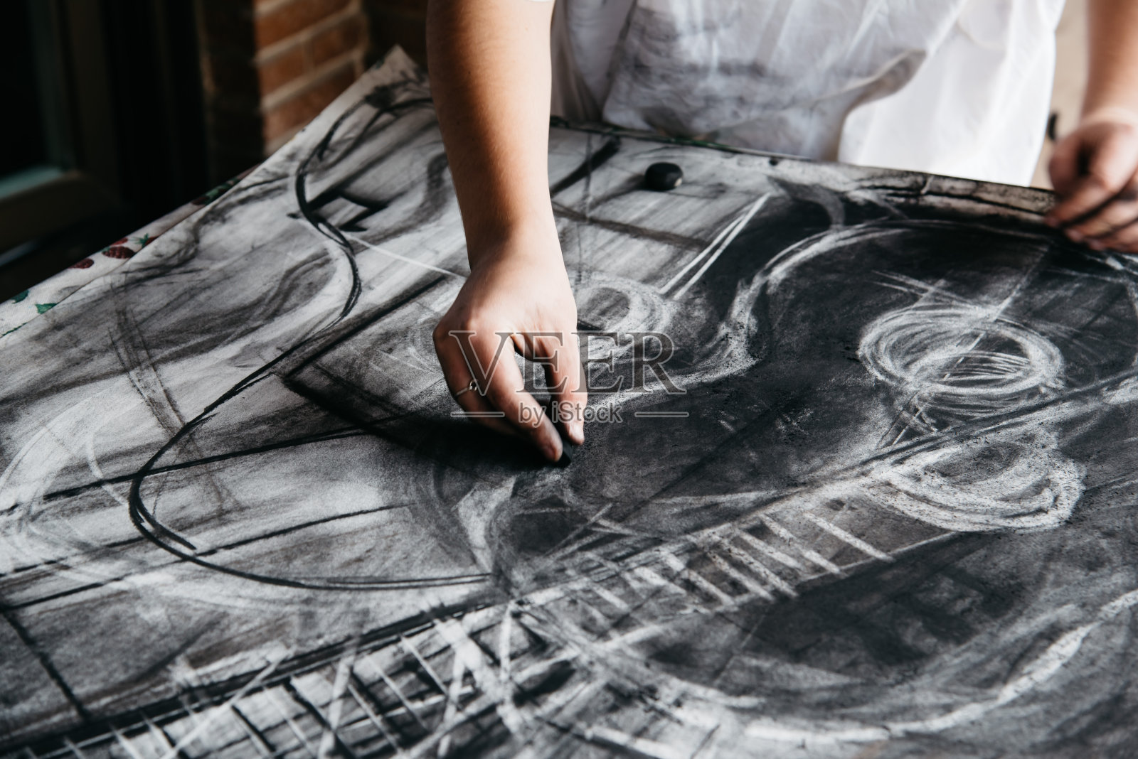 年轻的女画家用木炭在纸上作画照片摄影图片