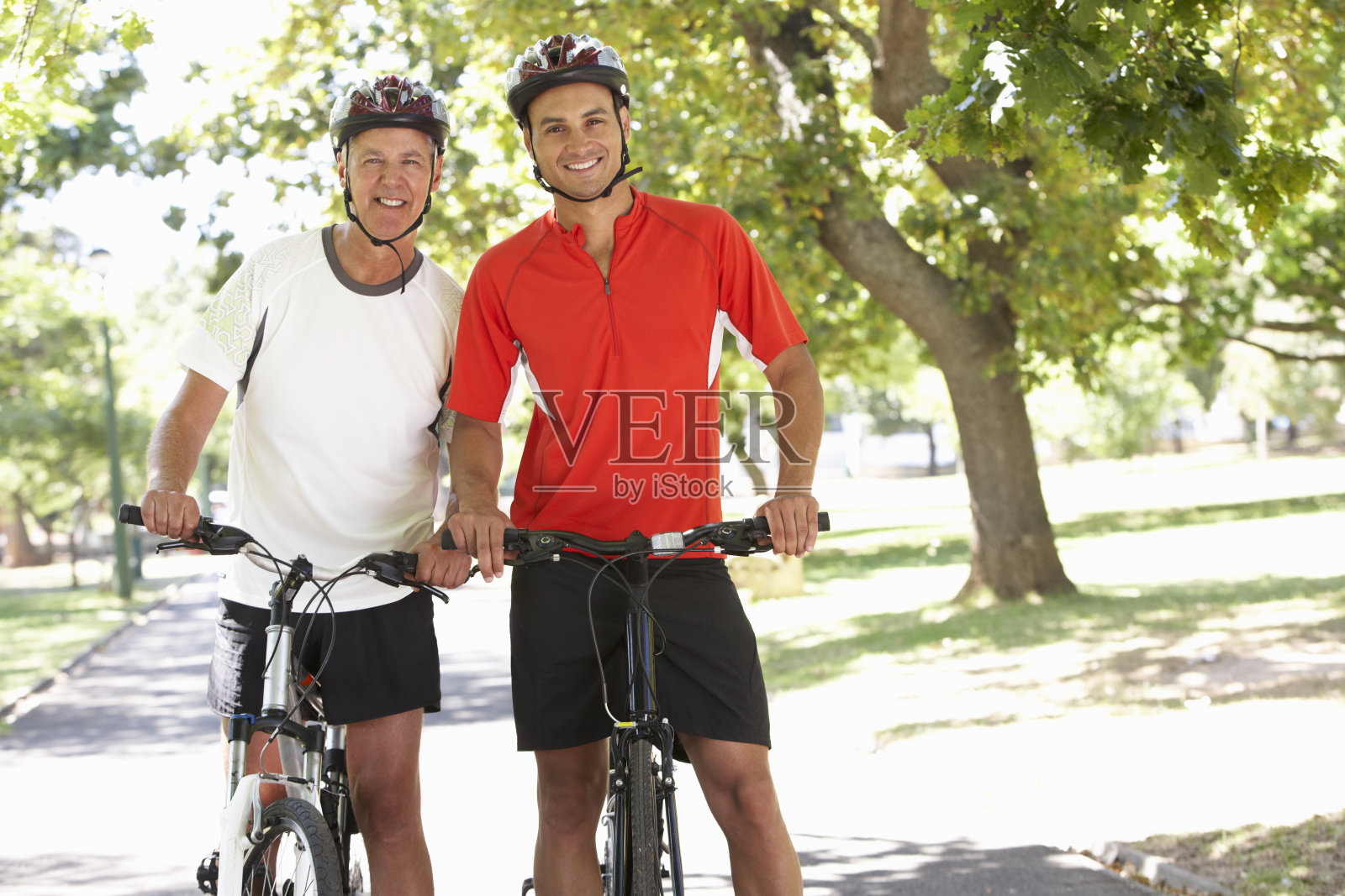 两个骑自行车穿过公园的人照片摄影图片