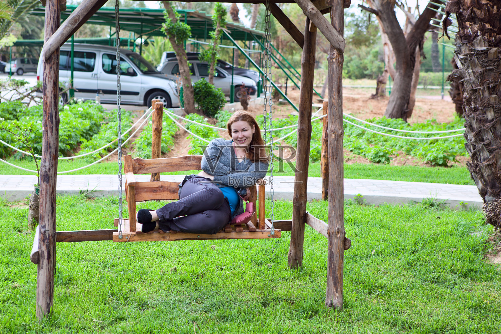 坐在公园长椅上的年轻女子照片摄影图片