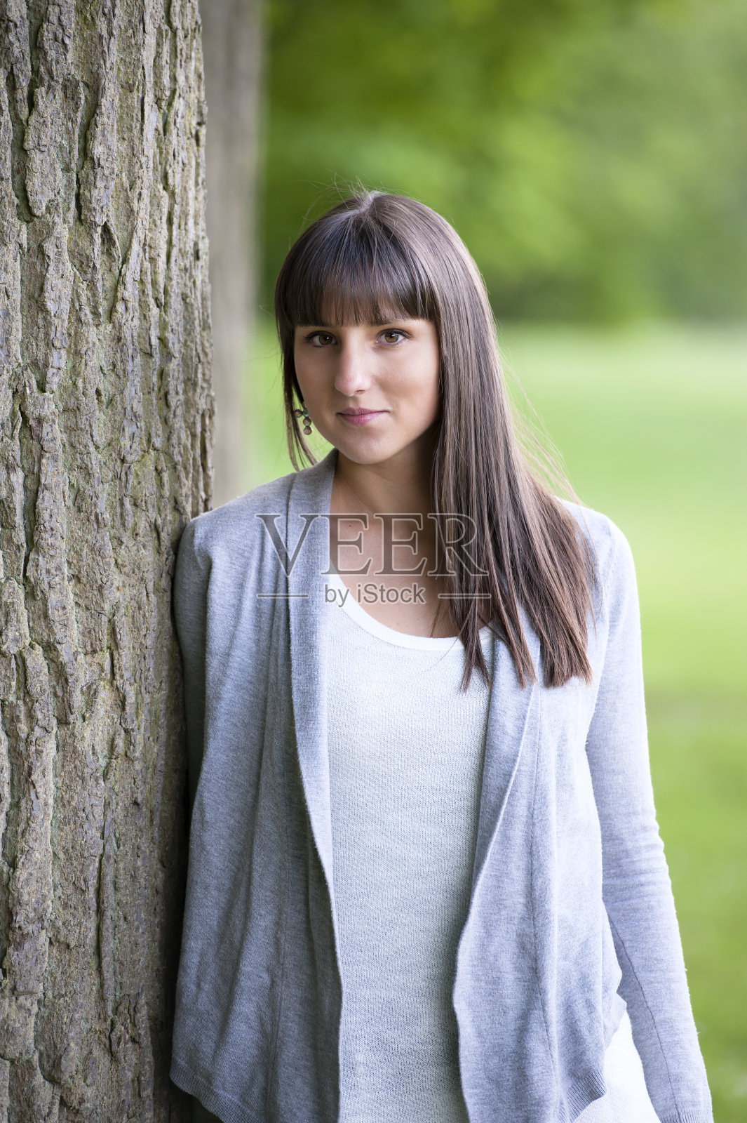 一个靠在树上的年轻女子照片摄影图片