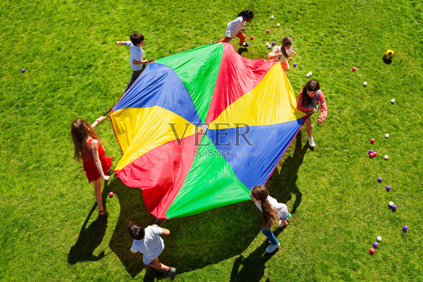 孩子们围着明亮的降落伞转着圈照片摄影图片