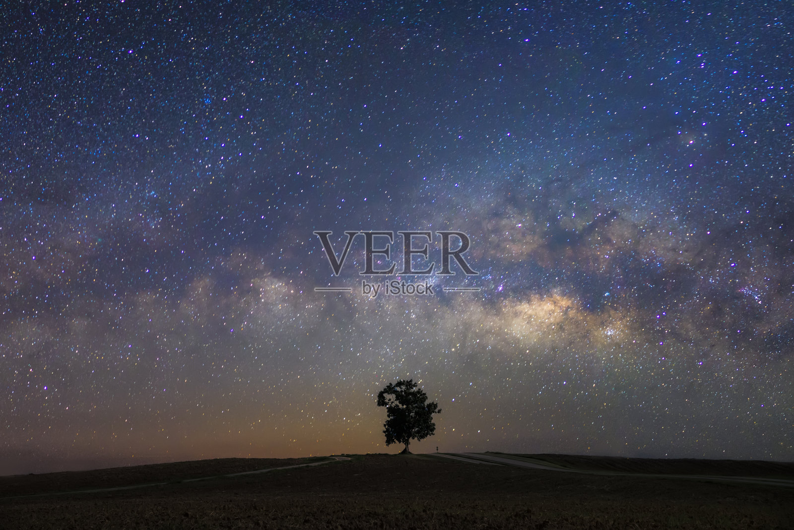美丽的银河与一个单一的树木背景。风景与夜晚星空和山上的一棵树照片摄影图片