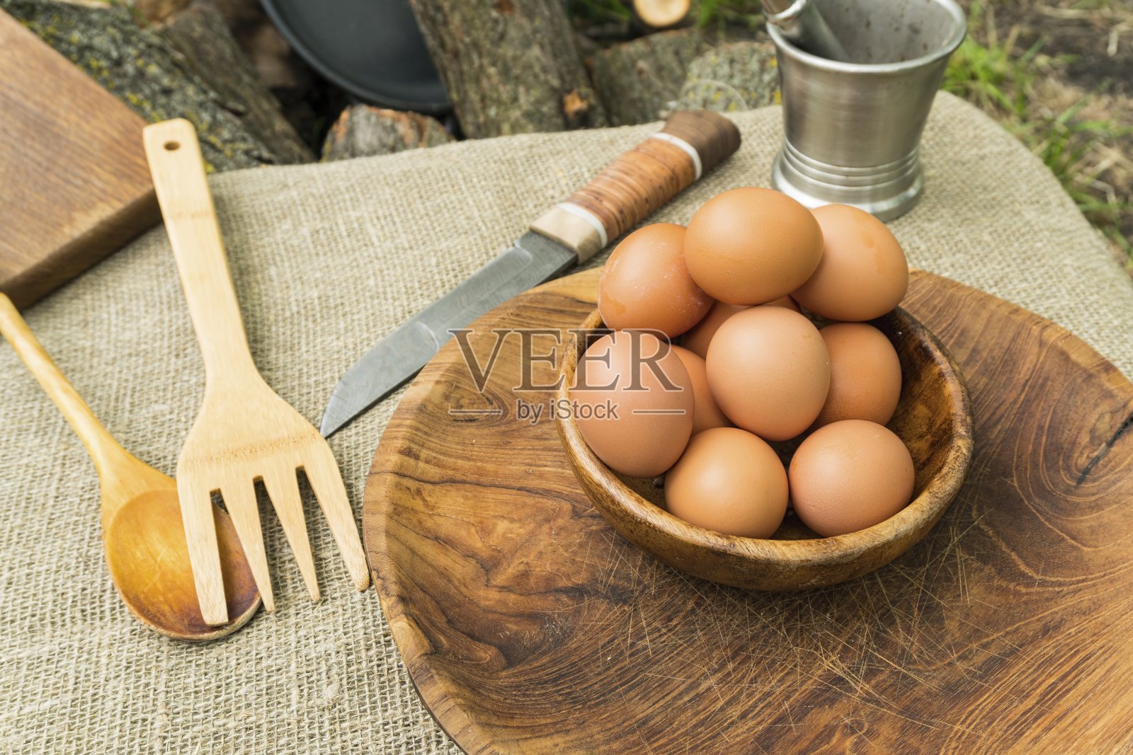 鸡蛋放在桌子上的木碗里。照片摄影图片