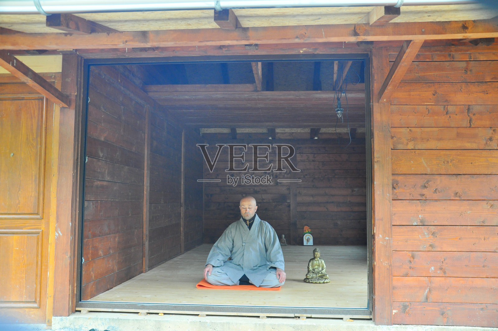 佛教冥想。一个老人在木屋里冥想。照片摄影图片