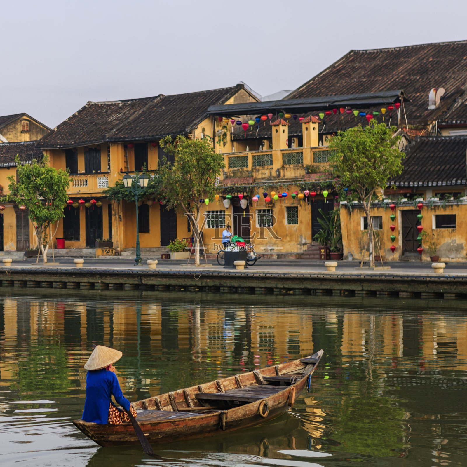 越南会安城，一名越南妇女在老城中划桨照片摄影图片