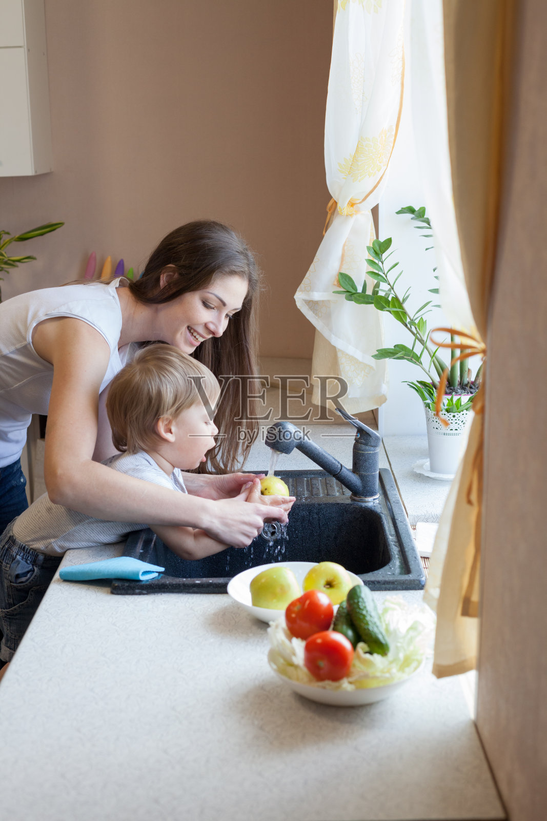 女儿在厨房帮妈妈干活照片摄影图片_ID:158524911-Veer图库