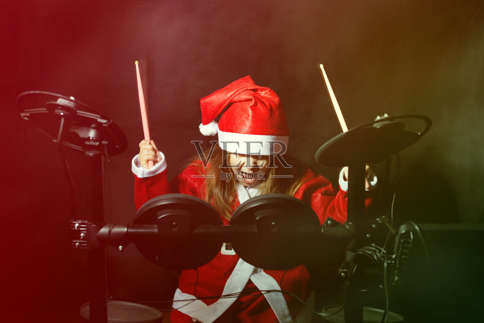 小鼓手装扮成圣诞老人打电子鼓包照片摄影图片