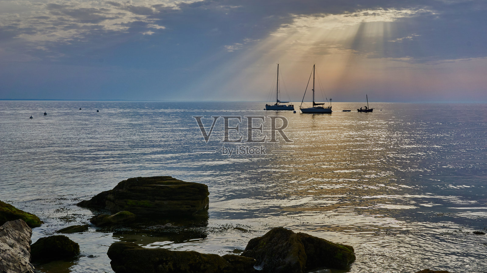 法国诺瓦穆蒂埃岛，大西洋上的黎明，阳光，云彩和船只照片摄影图片