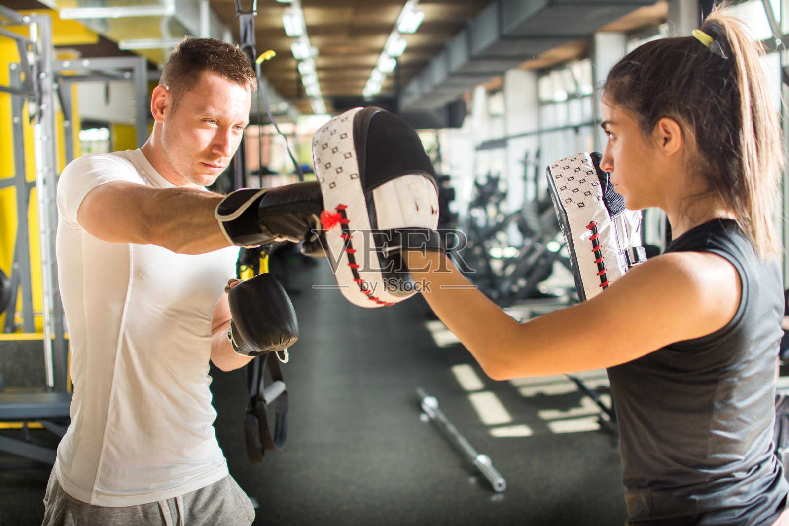 一对年轻夫妇在体育馆一起练习拳击。照片摄影图片