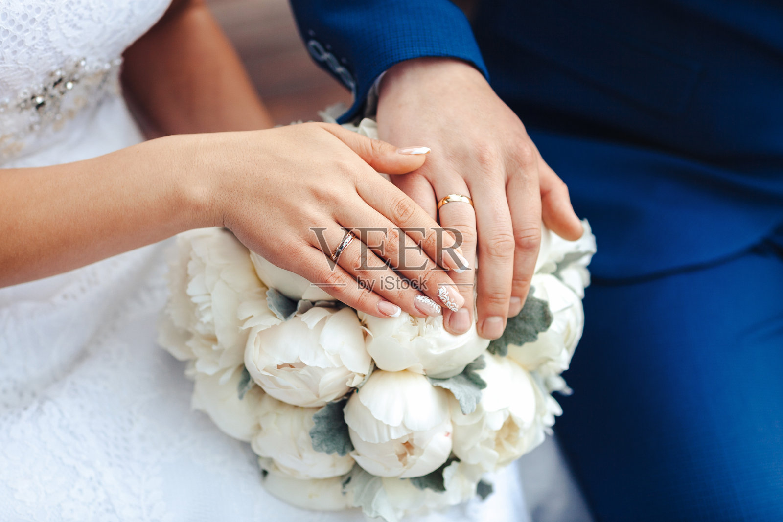 新娘手持戒指和婚礼花束照片摄影图片