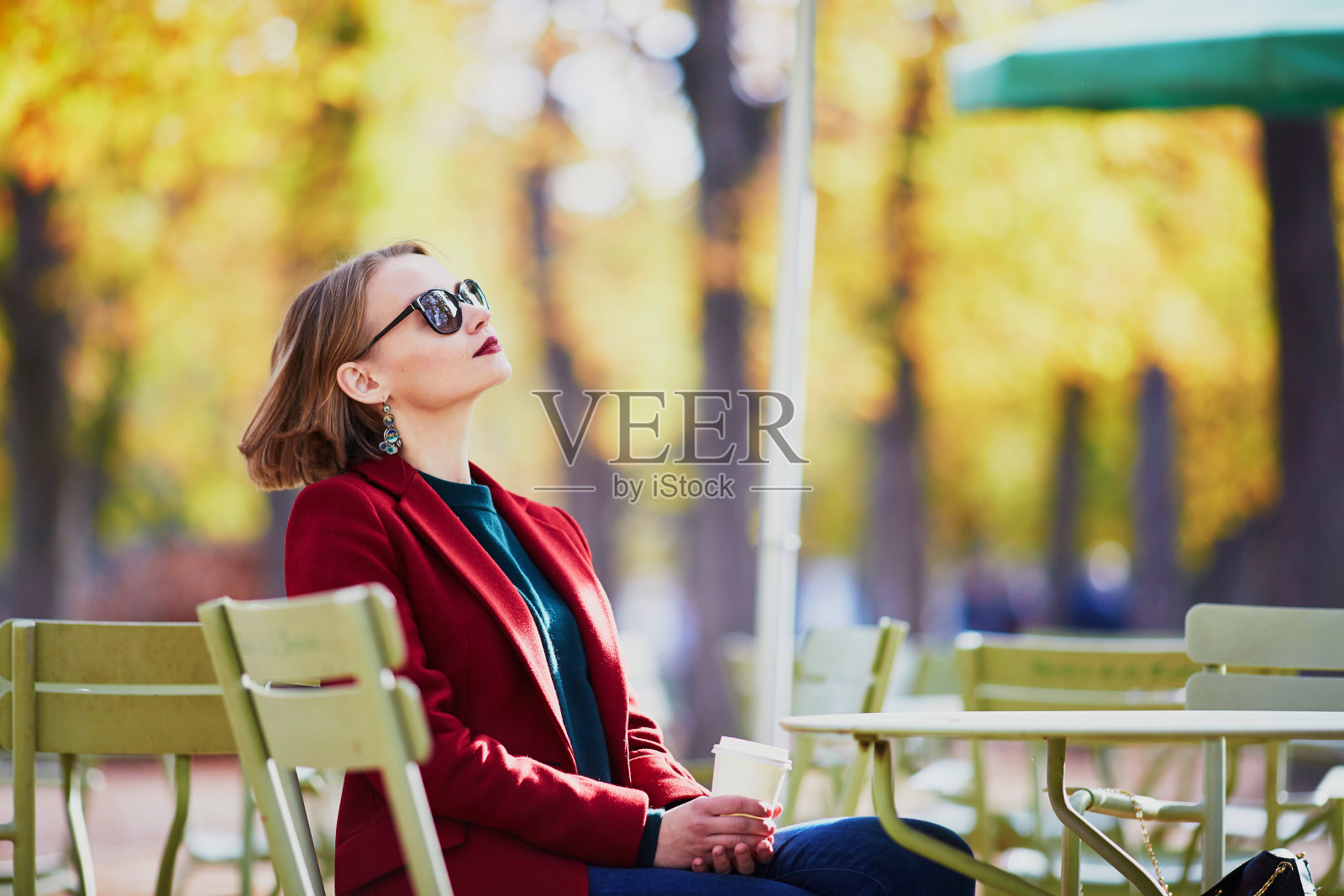 优雅的巴黎女子在公园喝咖啡照片摄影图片
