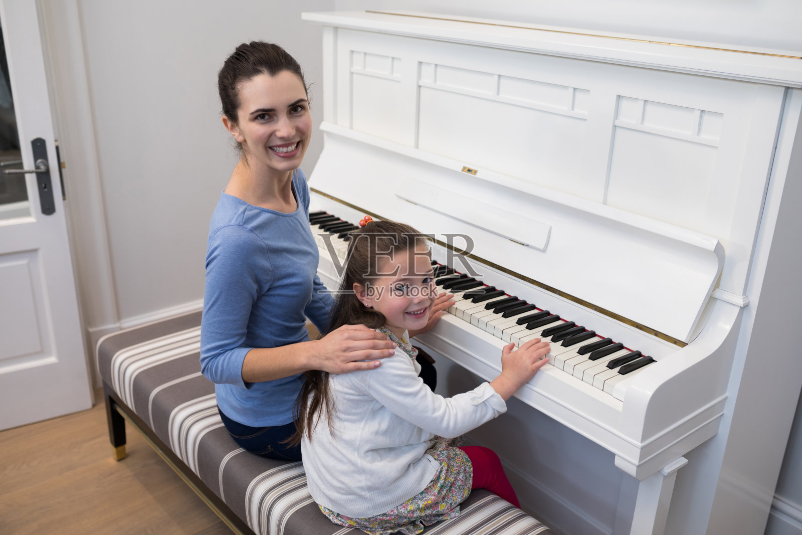 母亲协助女儿弹钢琴的肖像照片摄影图片
