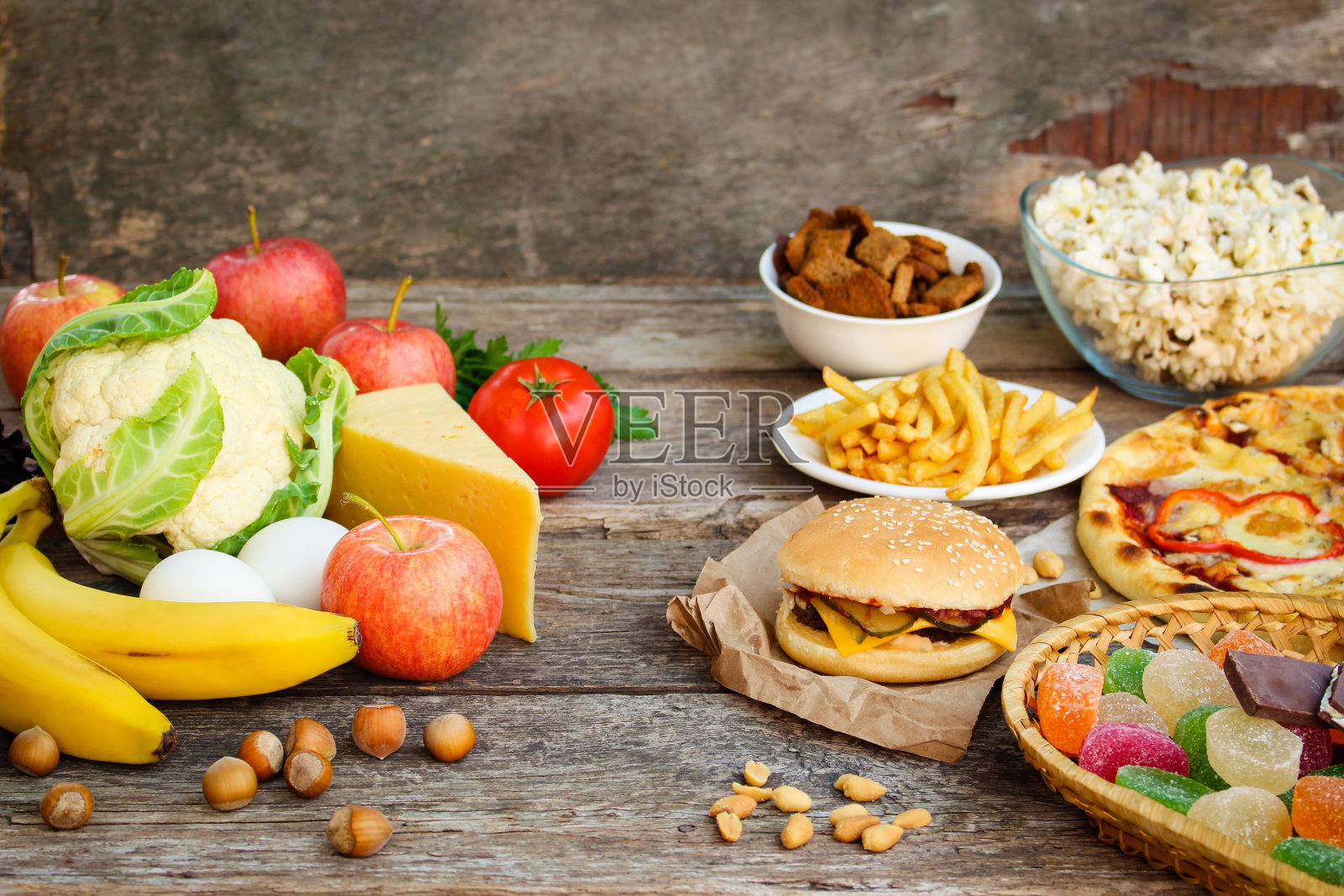 快餐和健康食品在旧的木制背景。概念选择正确的营养或垃圾食品。照片摄影图片
