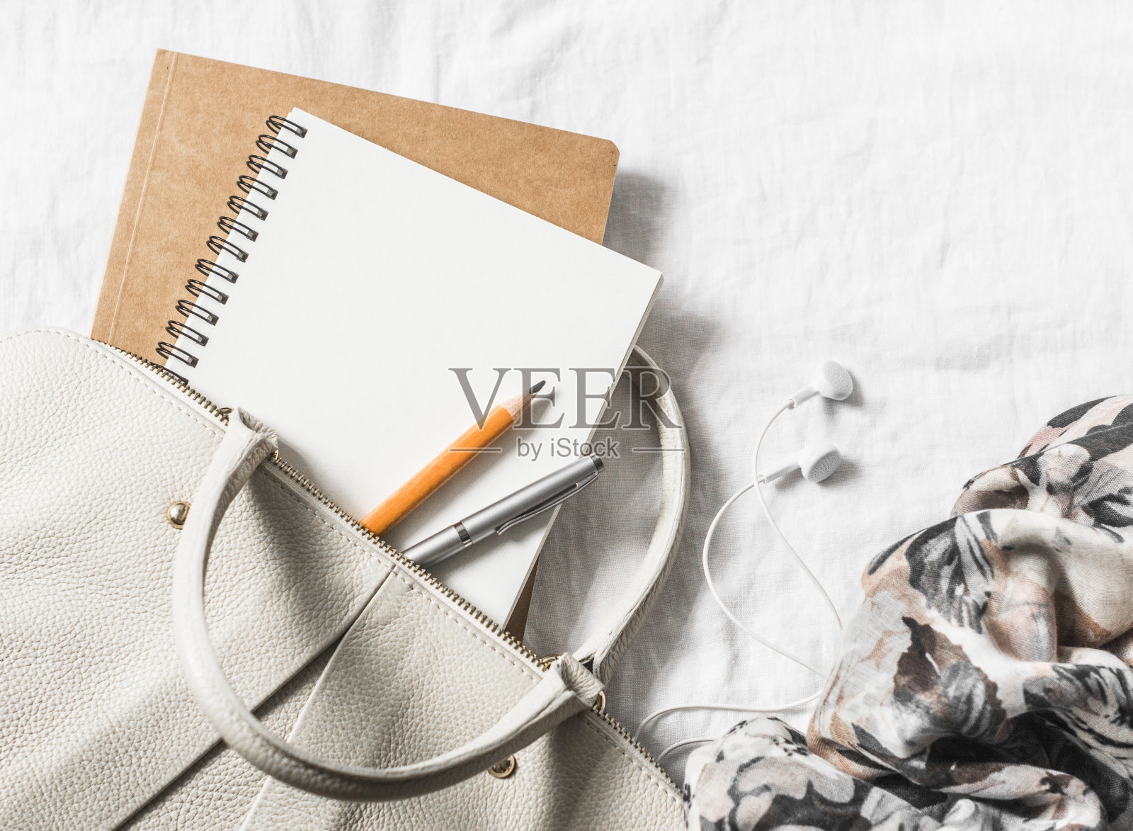 女士皮革手提包，干净的空白记事本，笔和围巾在一个轻的背景，俯视图。文本的空闲空间照片摄影图片