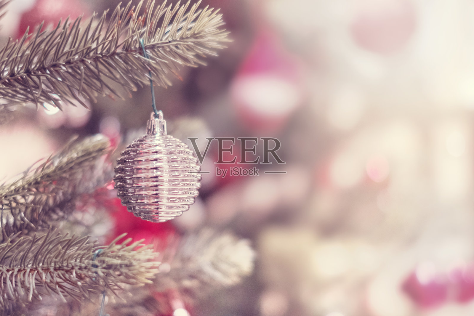 银色小玩意儿挂在圣诞树上的特写。照片摄影图片