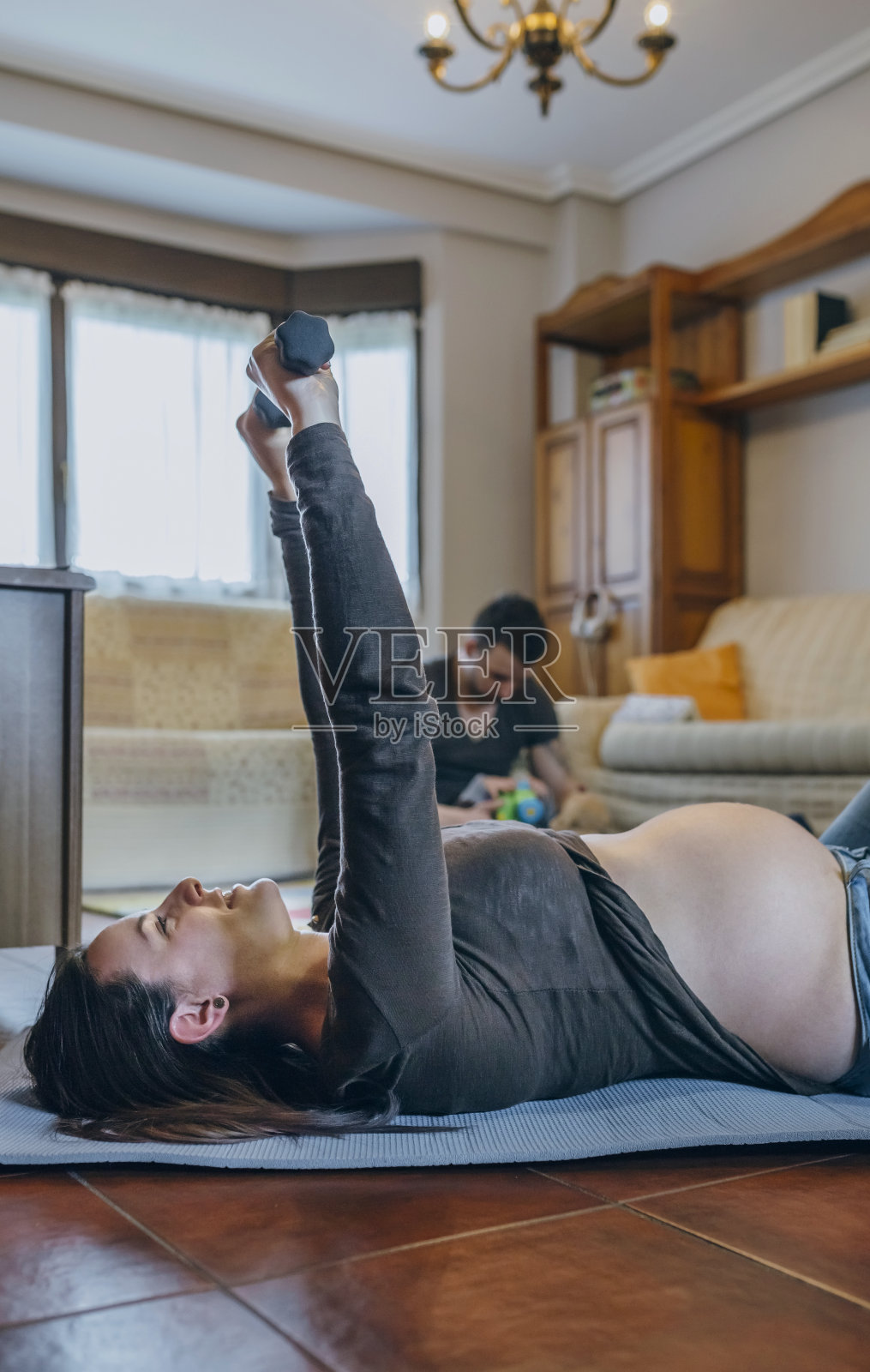 孕妇在客厅锻炼照片摄影图片