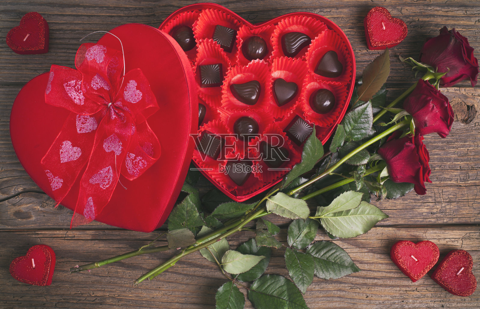 心形巧克力盒和红色玫瑰在木制的乡村背景照片摄影图片